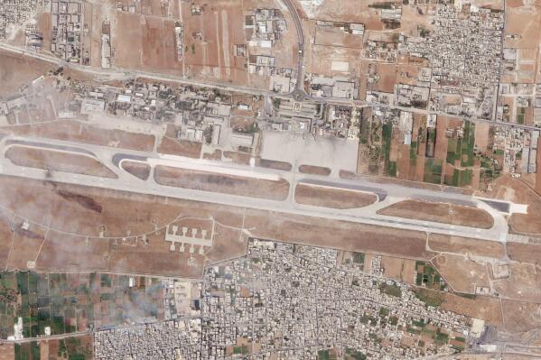 This satellite photo released by Planet Labs PBC shows the damage after an Israeli strike targeted the Aleppo International Airport, Thursday, Sept. 1, 2022. An Israeli attack targeting a Syrian airport tore a hole in the runway and also damaged a nearby piece of tarmac and structure on the military side of the airfield, satellite photos analyzed Friday by The Associated Press showed. (Planet Labs PBC via AP)