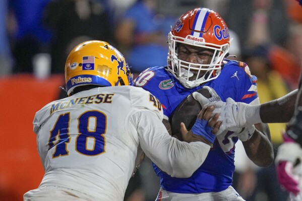 Florida running back Treyaun Webb, right, scores a touchdown against McNeese State linebacker Micah Davey (48) on a 2-yard run during the second half of an NCAA college football game, Saturday, Sept. 9, 2023, in Gainesville, Fla. (AP Photo/John Raoux)