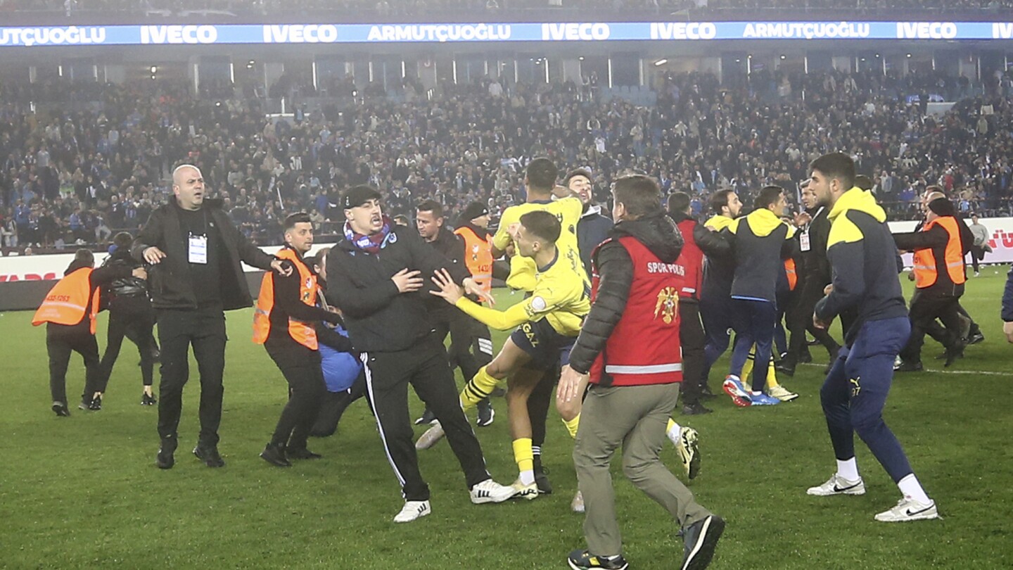 Les supporters de Trabzonspor envahissent le terrain et attaquent les joueurs de Fenerbahce en Turquie.  La police a arrêté 12 personnes
