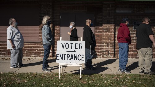 FILE - In this Tuesday, Nov. 3, 2020, file photo, voters wait in line outside a polling center on Election Day, in Kenosha, Wis. Republican lawmakers in Wisconsin and a statewide commission are in a standoff to determine who will oversee elections next year in one of the most important presidential battleground states. The conflict over reappointing the nonpartisan election director is rooted in the lies surrounding the last presidential election. (AP Photo/Wong Maye-E, File)