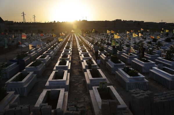 
              FILE - In this July 28, 2017, file photo, Kurdish citizens visit the graves of their relatives who were killed while fighting against Islamic State militants in Raqqa and other places, at a cemetery in Kobani, Syria. (AP Photo/Hussein Malla, File)
            