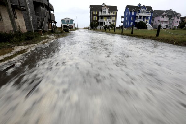 
              Ocean water rushes down Cape Hatteras Pier Drive in Frisco, N.C.,  on Hatteras Island as the effects of Hurricane Florence reach the area on Thursday, Sept. 13, 2018.  (Steve Earley /The Virginian-Pilot via AP)
            