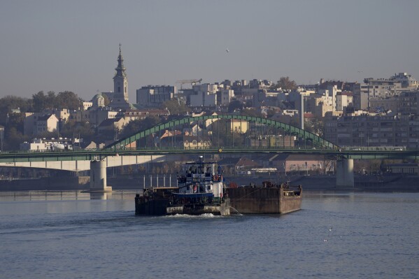 FILE - A boat floats on the Sava river in the morning in Belgrade, Serbia, Friday, Oct. 29, 2021. A cargo vessel loaded with fertilizers has sank after hitting a bridge on the Danube River border between Serbia and Croatia, prompting fears of a potential ecological disaster, authorities said Friday. Serbia's Environment Ministry said that the barge which sank some 40 minutes after midnight was carrying 1,000 tons of nitrogen fertilizers, adding that the Environmental Protection Agency was monitoring the situation on the Danube. (AP Photo/Darko Vojinovic, File)