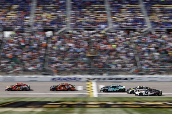 Racers head toward Turn 1 during a NASCAR Cup Series auto race at Kansas Speedway in Kansas City, Kan., Sunday, Sept. 10, 2023. (AP Photo/Colin E. Braley)