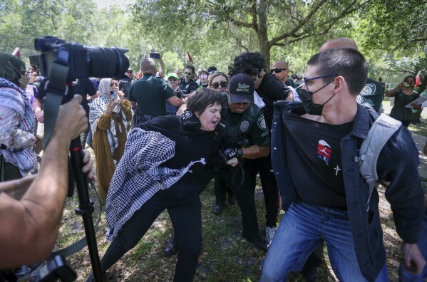 A pro-Palestinian protester is grabbed by University of South Florida police as they begin to clash on campus Monday, April 29, 2024, in Tampa, Fla. (Chris Urso/Tampa Bay Times via AP)