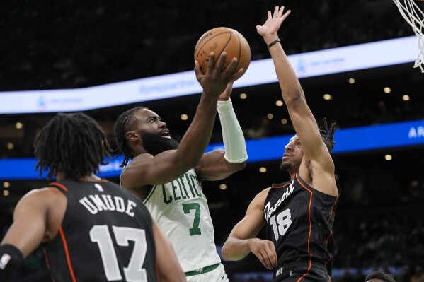 Jaylen Brown (7), de los Celtics de Boston, dispara contra Tosan Evbuomwan (18), de los Pistons de Detroit, durante la segunda mitad de un partido de baloncesto de la NBA, el lunes 18 de marzo de 2024, en Boston. (AP Foto/Michael Dwyer)