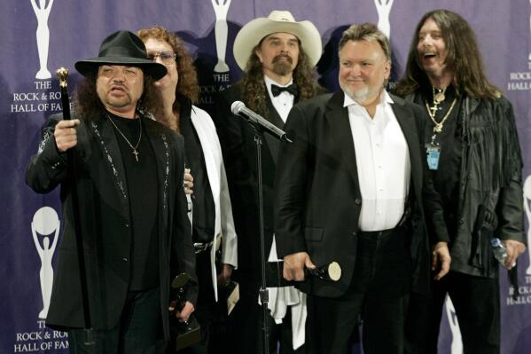 FILE - The band Lynyrd Skynyrd, from left, Gary Rossington, Billy Powell, Artimus Pyle, Ed King and Bob Burns appear backstage after being inducted at the Rock and Roll Hall of Fame in New York on March 13, 2006. Rossington, the iconic band's last surviving cofounder, who died Sunday, March 5, was also perhaps the last flag pole in a once powerful part of American culture: Southern rock. (AP Photo/Stuart Ramson, File)