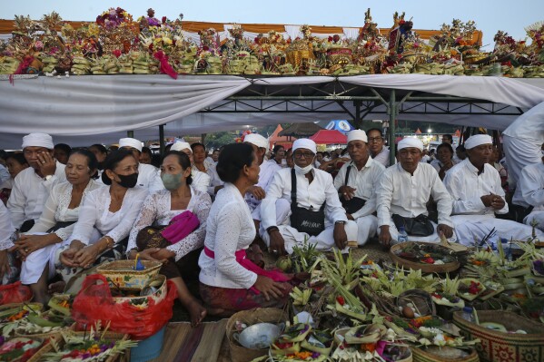 Balinese Hindus wait with offerings to participate in a purification ceremony on Melasti at Padanggala beach in Bali, Indonesia on Friday, March 8, 2024. Melasti is part of the six-day long Balinese Hindu New Year, where devout perform rituals as an act of symbolic cleansing. (AP Photo/Firdia Lisnawati)