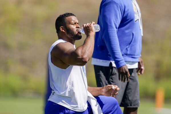 Los Angeles Rams defensive tackle Aaron Donald drinks water during a joint NFL football practice with the Las Vegas Raiders, Wednesday, Aug. 16, 2023, in Thousand Oaks, Calif. (AP Photo/Ryan Sun)