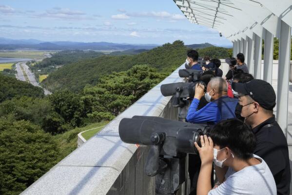 Visitors watch the North Korea side from the Unification Observation Post in Paju, South Korea, near the border with North Korea, Sunday, Sept. 26, 2021. The powerful sister of North Korean leader Kim Jong Un said Saturday that her country will take steps to repair ties with South Korea, and may even discuss another summit between their leaders, if the South drops what she described as hostility and double standards. (AP Photo/Ahn Young-joon)