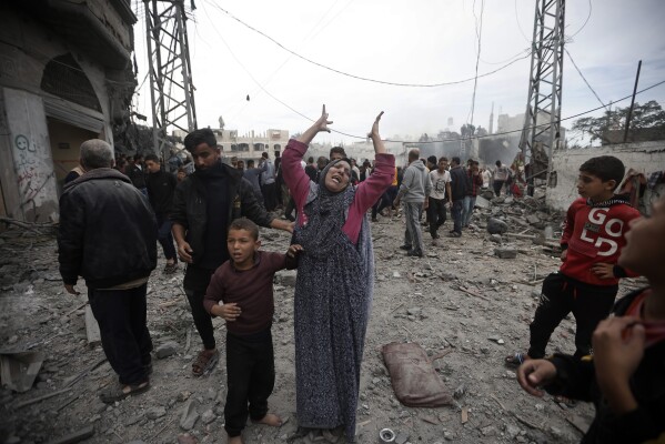 A Palestinian woman gestures following Israeli airstrikes in Khan Younis refugee camp, southern Gaza Strip, Thursday, Dec. 7, 2023. (AP Photo/Mohammed Dahman)