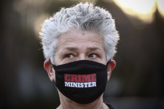 A woman wears a protective face mask amid concerns over the country's coronavirus outbreak, take part in a protest against Prime Minister Benjamin Netanyahu in Tel Aviv, Israel, Sunday, April 19, 2020. More than 2,000 people took to the streets on Sunday, demonstrating against Prime Minister Benjamin Netanyahu's attempts to form an "emergency" government with his chief rival and accusing him of using the coronavirus crisis to escape prosecution on corruption charges. (AP Photo/Oded Balilty)