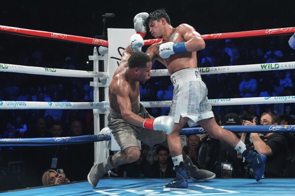 Ryan Garcia, right, knocks down Devin Haney during the 10th round of a super lightweight boxing match early Sunday, April 21, 2024, in New York. Garcia won the fight. (AP Photo/Frank Franklin II)