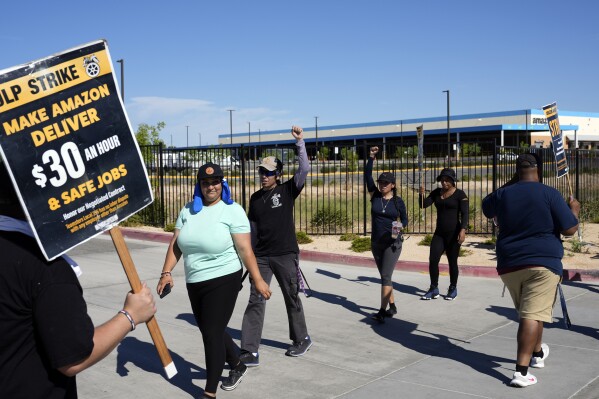 Workers picket outside an Amazon distribution center on Monday, July 24, 2023, in Palmdale, Calif. Dozens of Amazon drivers and dispatchers who work for a California-based delivery firm the Teamsters unionized in April have been picketing company warehouses, calling on the e-commerce behemoth to come to the table and bargain over pay and working conditions. (AP Photo/Marcio Jose Sanchez)