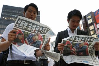 
              People look at the extra edition of  Japanese newspaper Mainichi Shimbun reporting the summit between U.S. President Donald Trump and North Korean leader Kim Jong Un in Singapore, at Shimbashi Station in Tokyo, Tuesday, June 12, 2018.  The headline reads: North Korea promises to denuclearize. (Suo Takekuma/Kyodo News via AP)
            