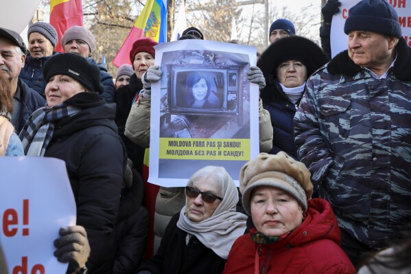 A woman holds a banner showing the country's president, Maia Sandu, that reads 