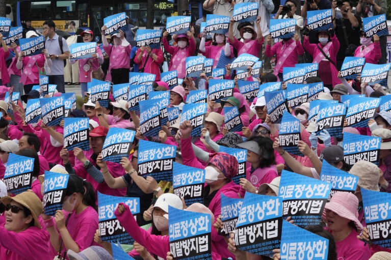 Patients and their family members stage a rally demanding doctors to end the ongoing walkout that has disrupted public health services in Seoul, South Korea, Thursday, July 4, 2024. Since February, more than 12,000 trainee doctors have been on strike in a deepening standoff with government officials, who want to grow the country's number of doctors by up to 10,000 by 2035. The signs read 