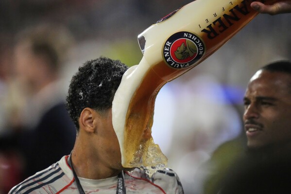 Bayern's Jamal Musiala is doused with beer after the German Bundesliga's soccer match between FC Bayern Munich and Borussia Moenchengladbach in Munich, Germany, May 10, 2025. (AP Photo/Matthias Schrader)