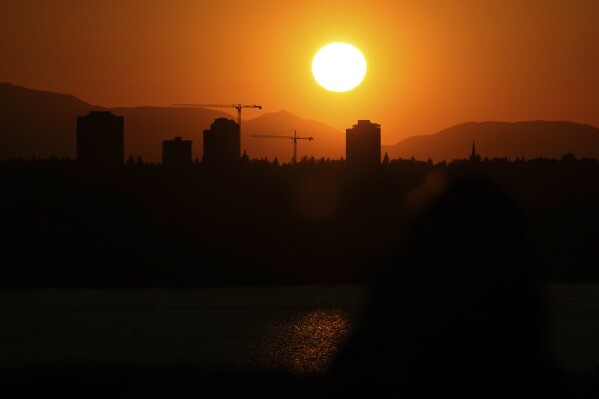 FILE - The sun sets over the University District in Seattle, May 13, 2023, seen from 520 Bridge View Park in Medina, Wash. A hazardous heat wave is expected to bring scorching temperatures to the Pacific Northwest this week, Monday, Aug. 14, according to the National Weather Service. (AP Photo/ Lindsey Wasson, File)