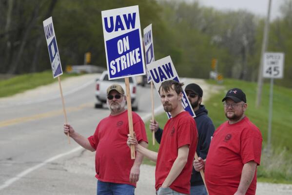 FILE - Members of United Auto Workers Local 807 carry picket signs after going on strike, May 2, 2022, at a CNH plant in Burlington, Iowa. More than 1,000 striking CNH Industrial workers in Iowa and Wisconsin will soon vote on an offer from the maker of construction and agricultural equipment for the first time since they walked off the job eight months ago. The UAW union said it would schedule a vote on the company’s latest upgraded offer but it did not release any details of what is included in the offer. (John Loveretta/The Hawk Eye via AP, File)