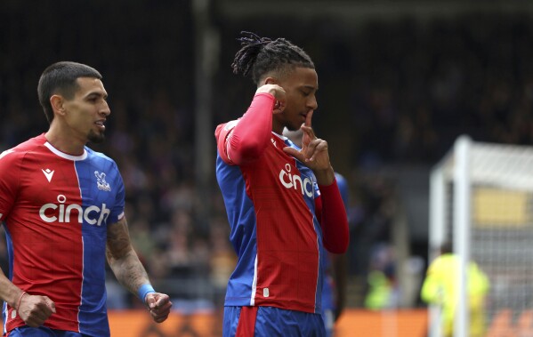 Crystal Palace's Michael Olise, right, celebrates scoring their first goal of the game during the English Premier League soccer match between West Ham United and Crystal Palace at Selhurst Park in London, Sunday April 21, 2024. (Steven Paston/PA via AP)