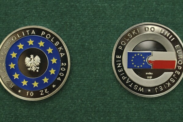 FILE - A multicolor 10 Polish Zloty coin marking Poland entering the European Union is presented by the National Bank of Poland in Warsaw, on April 14, 2004. The finance minister in Poland’s pro-European Union government says the country is still not ready to adopt the euro currency. The finance minister in the Cabinet of Prime Minister Donald Tusk said that Poland joining the eurozone, the currency union of 20 EU members, is not justified at this time. (AP Photo/Alik Keplicz, File)