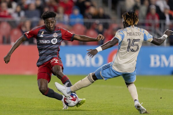 Toronto FC forward Deandre Kerr (29) scores as Philadelphia Union defender Olivier Mbaizo (15) defends during the second half of an MLS soccer match Wednesday, Aug. 30, 2023, in Toronto. (Spencer Colby/The Canadian Press via AP)
