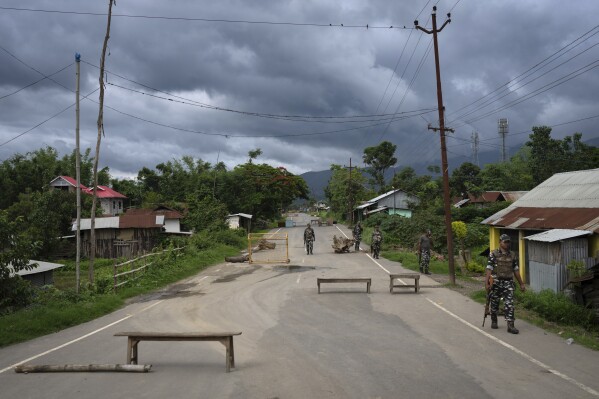 Indian paramilitary soldiers patrol a deserted street at a de facto frontline which dissect the area into two ethnic zones in Kwakta, near Churachandpur, some 50 kms from Imphal, capital of the northeastern Indian state of Manipur, Thursday, June 22, 2023. Witnesses interviewed by The Associated Press described how angry mobs and armed gangs swept into villages and towns, burning down houses, massacring civilians, and driving tens of thousands from their homes. More than 50,000 people have fled to packed relief camps. (AP Photo/Altaf Qadri)