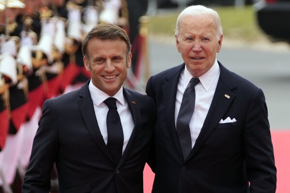 FILE - President Joe Biden, right, and French President Emmanuel Macron arrive at the international ceremony at Omaha Beach, June 6, 2024, in Normandy, France. Biden is being feted with a state visit this weekend by Macron in Paris.(AP Photo/Virginia Mayo, Pool)