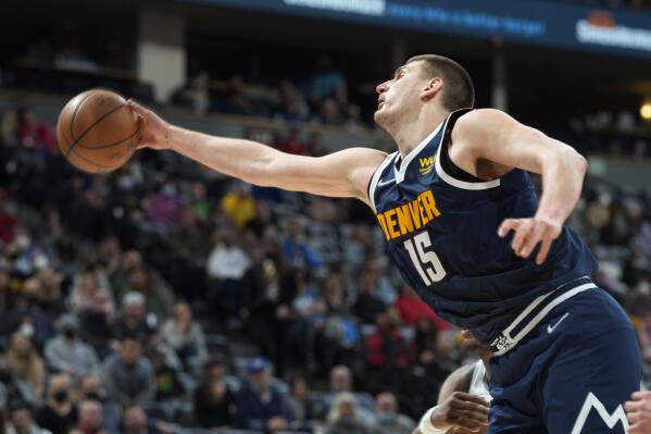 Denver Nuggets center Nikola Jokic reaches out for a loose ball during the second half of an NBA basketball game against the Orlando Magic on Monday, Feb. 14, 2022, in Denver. The Nuggets won 121-111. (AP Photo/David Zalubowski)