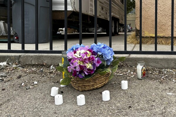 A makeshift memorial for a high school student lines a fence along an alleyway near Rancho High School in eastern Las Vegas on Wednesday, Nov. 15, 2023. Authorities arrested eight teens Tuesday in connection with the beating of Jonathan Lewis Jr., who died a week after a prearranged fight over a pair of headphones and a vape pen. (AP Photo/Rio Yamat)