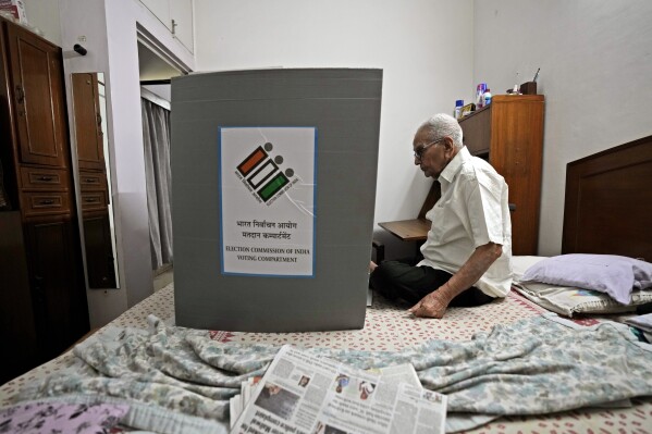 K. Datta, 91, casts his vote sitting in his home, in New Delhi, India, Friday, May 17, 2024. To encourage and assist elderly persons to cast their votes, the Election Commission of India initiated the home voting facility for the ongoing general parliamentary elections. (AP Photo/Manish Swarup)