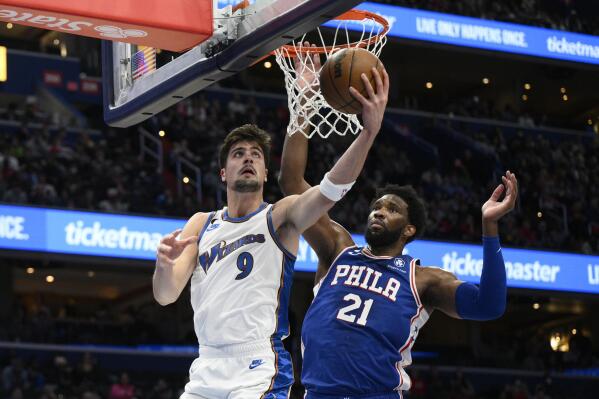 Washington Wizards forward Deni Avdija (9) goes to the basket against Philadelphia 76ers center Joel Embiid (21) during the first half of an NBA basketball game, Tuesday, Dec. 27, 2022, in Washington. (AP Photo/Nick Wass)