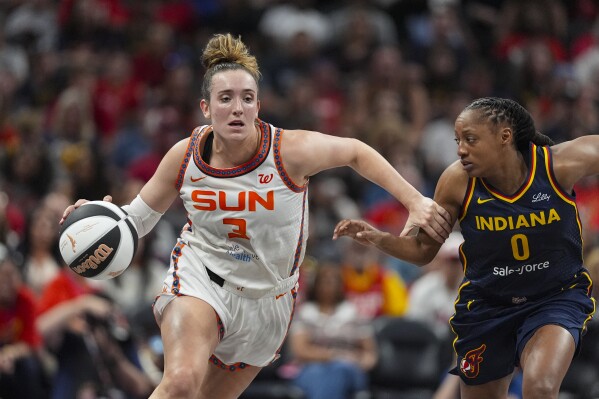 Connecticut Sun guard Marina Mabrey (3) drives on Indiana Fever guard Kelsey Mitchell (0) in the first half of a WNBA basketball game in Indianapolis, Tuesday, June 17, 2025. (AP Photo/Michael Conroy)