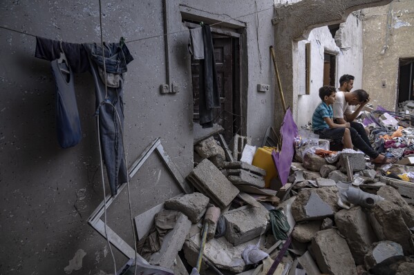 Palestinians sit on the rubble of a house after it was struck by an Israeli airstrike in Khan Younis, southern Gaza Strip, Sunday, Oct. 29, 2023. (AP Photo/Fatima Shbair)