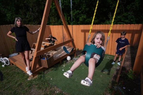 Eileen Lamb, from left, who was diagnosed with autism as an adult, watches over her children, Charlie Lamb and Jude, right, who also have autism, and daughter Billie, Monday, May 12, 2025, in Austin, Texas. (AP Photo/Eric Gay)