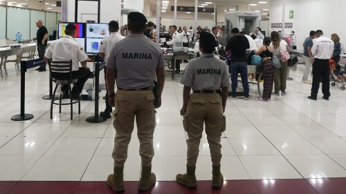 FILE - Mexican Navy officers stand guard next to a security checkpoint at the Benito Juarez International Airport, in Mexico City, Friday, June 30, 2023. Mexico's armed forces are taking control of the capital's main airport and the government plans to give the military control of nearly a dozen more across the country as the president aims at corruption and mismanagement. (AP Photo/Fernando Llano, File)