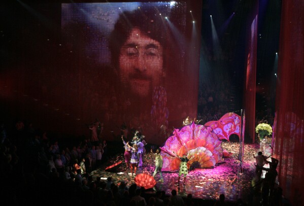 FILE - A photo of Beatles member John Lennon is projected on the screen during the preview of "Love," a new Beatles-themed Cirque du Soleil show, in Las Vegas, June 27, 2006. On Tuesday, April 9, 2024, it was announced that the final curtain will come down July 7 on Cirque du Soleil's long-running show “The Beatles Love," a cultural icon on the Las Vegas Strip that brought band members Paul McCartney and Ringo Starr back together for public appearances throughout its 18-year run. (AP Photo/Jae C. Hong, File)
