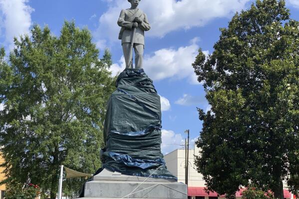 FILE - A Confederate monument in Tuskegee, Ala., is shown with its base wrapped in tarps on June 12, 2020. Circuit Judge Steven Perryman on Thursday, Jan. 26, 2023 has paved the way for officials to remove a Confederate monument placed a century ago at the center of a historic, majority-Black city as part of a "park for white people." (AP Photo/Kim Chandler, File)