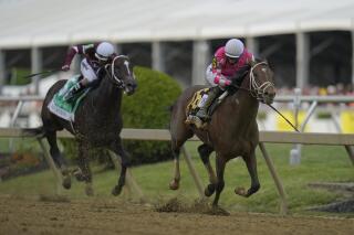 Flavien Prat atop Rombauer, right, breaks away from Irad Ortiz Jr. atop Midnight Bourbon moments before crossing the finish line to win the Preakness Stakes horse race at Pimlico Race Course, Saturday, May 15, 2021, in Baltimore. (AP Photo/Julio Cortez)