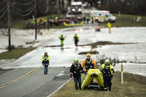 First responders move to put away their equipment after a person stranded by the floodwaters of the Perkiomen Creek near Graterford Road in Collegeville, Pa., was rescued, Monday, Dec. 18, 2023. (AP Photo/Matt Rourke)