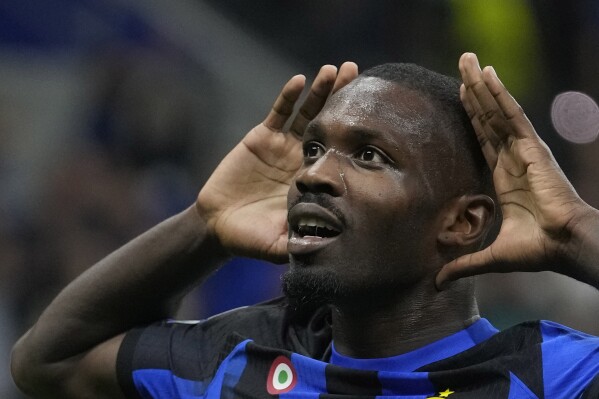 Inter Milan's Marcus Thuram, left, celebrates after scoring his side's opening goal during the Champions League, Group D soccer match between Inter Milan and Benfica, at the San Siro stadium in Milan, Italy, Tuesday, Oct. 3, 2023. (AP Photo/Luca Bruno)