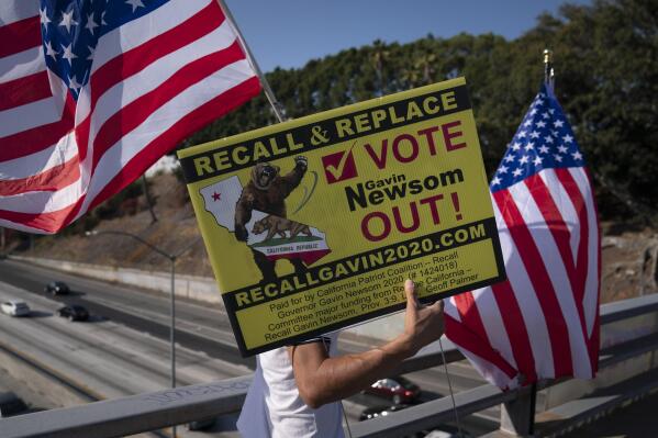 FILE - Zig Jiang, 47, carries a sign calling for a recall on California Gov. Gavin Newsom on a bridge overlooking the 101 Freeway, Wednesday, Sept. 8, 2021, in Los Angeles. Weeks after Gov. Newsom fended off an attempt to remove him from office in mid-term, his fellow Democrats on Thursday, Oct. 28, 2021, began eyeing ways to make future challenges more difficult. (AP Photo/Jae C. Hong, File)