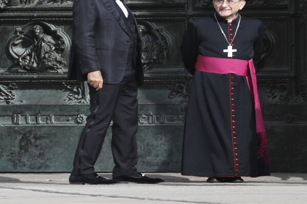 FILE - In this Sunday, April 12, 2020, Italian singer Andrea Bocelli stands next to Archbishop of Milan Mario Delpini prior to performing outside the Duomo cathedral, on Easter Sunday, in Milan, Italy. Italian tenor Andrea Bocelli, who had COVID-19, says the pandemic lockdown in his country made him feel “humiliated and offended” for depriving him of freedom. Bocelli spoke at a panel held on Monday in a Senate conference room, where he was introduced by right-wing opposition leader Matteo Salvini, who has railed against the government's stringent measures aimed at reining in the coronavirus outbreak. (AP Photo/Luca Bruno, File)