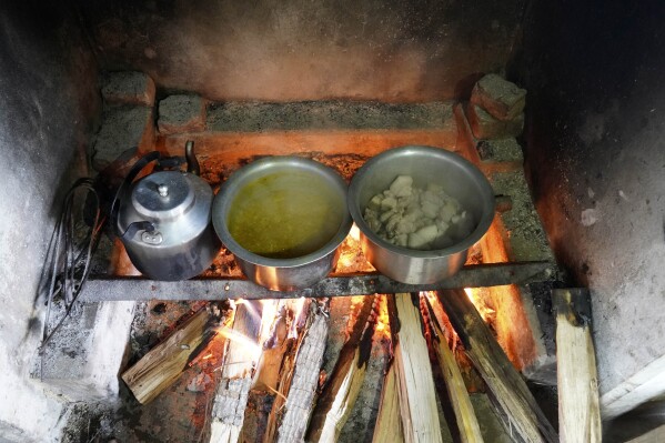 A meal of meat and lentils cook over an open fire, meant for polling officers on the eve of polling in Chedema village, in the northeastern Indian state of Nagaland, Thursday, April 18, 2024. (AP Photo/Yirmiyan Arthur)