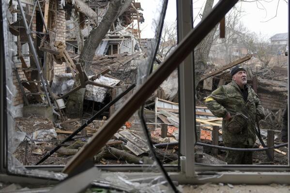 Andrey Goncharuk, 68, a member of the territorial defense stands in the backyard of a house damaged by a Russian airstrike, according to locals, in Gorenka, outside the capital Kyiv, Ukraine, Wednesday, March 2, 2022. Russia renewed its assault on Ukraine's second-largest city in a pounding that lit up the skyline with balls of fire over populated areas, even as both sides said they were ready to resume talks aimed at stopping the new devastating war in Europe. (AP Photo/Vadim Ghirda)