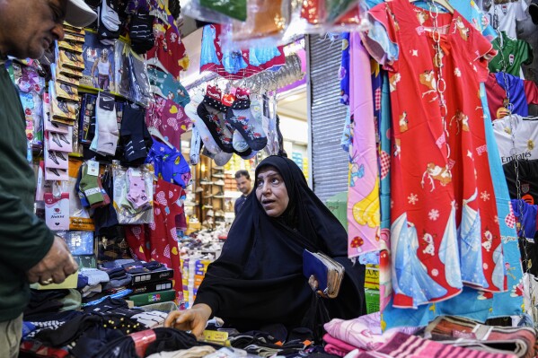 An Iraqi woman buy clothes for Eid al-Fitr at the Shorjah market in central Baghdad, Iraq, Thursday, March 27, 2025. Eid al-Fitr marks the end of the holy fasting month of Ramadan. (AP Photo/Hadi Mizban)