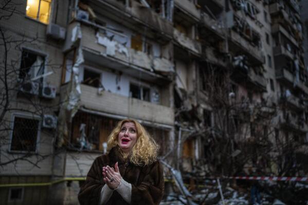 Natali Sevriukova is overcome with emotion as she stands outside her destroyed apartment building following a rocket attack in Kyiv, Ukraine, Friday, Feb. 25, 2022. (AP Photo/Emilio Morenatti)