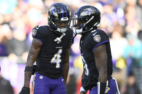 Baltimore Ravens quarterback Lamar Jackson (8) and wide receiver Zay Flowers (4) celebrate their touchdown against the Miami Dolphins during the first half of an NFL football game in Baltimore, Sunday, Dec. 31, 2023. (AP Photo/Nick Wass)