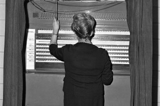 A voter casts her ballot at a voting machine in Baltimore on Dec. 8, 1964. (AP Photo/William Smith )